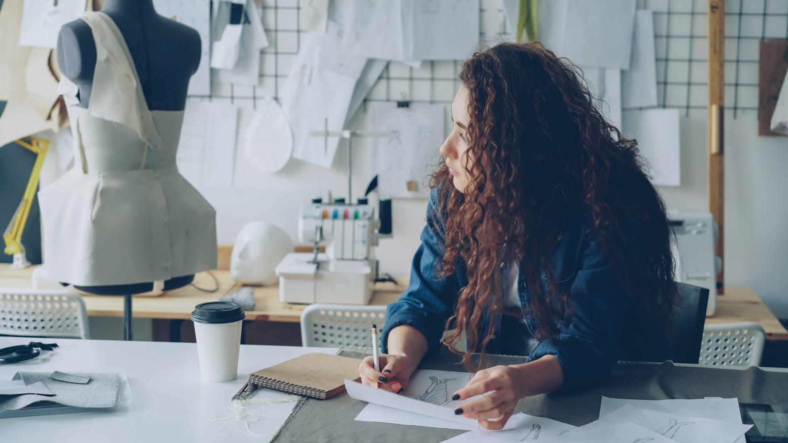 10 Design Trends Creatives Are Exhausted By in 2026 9 Designer working in creative studio workspace with design tools and materials for design trends creatives are tired of article