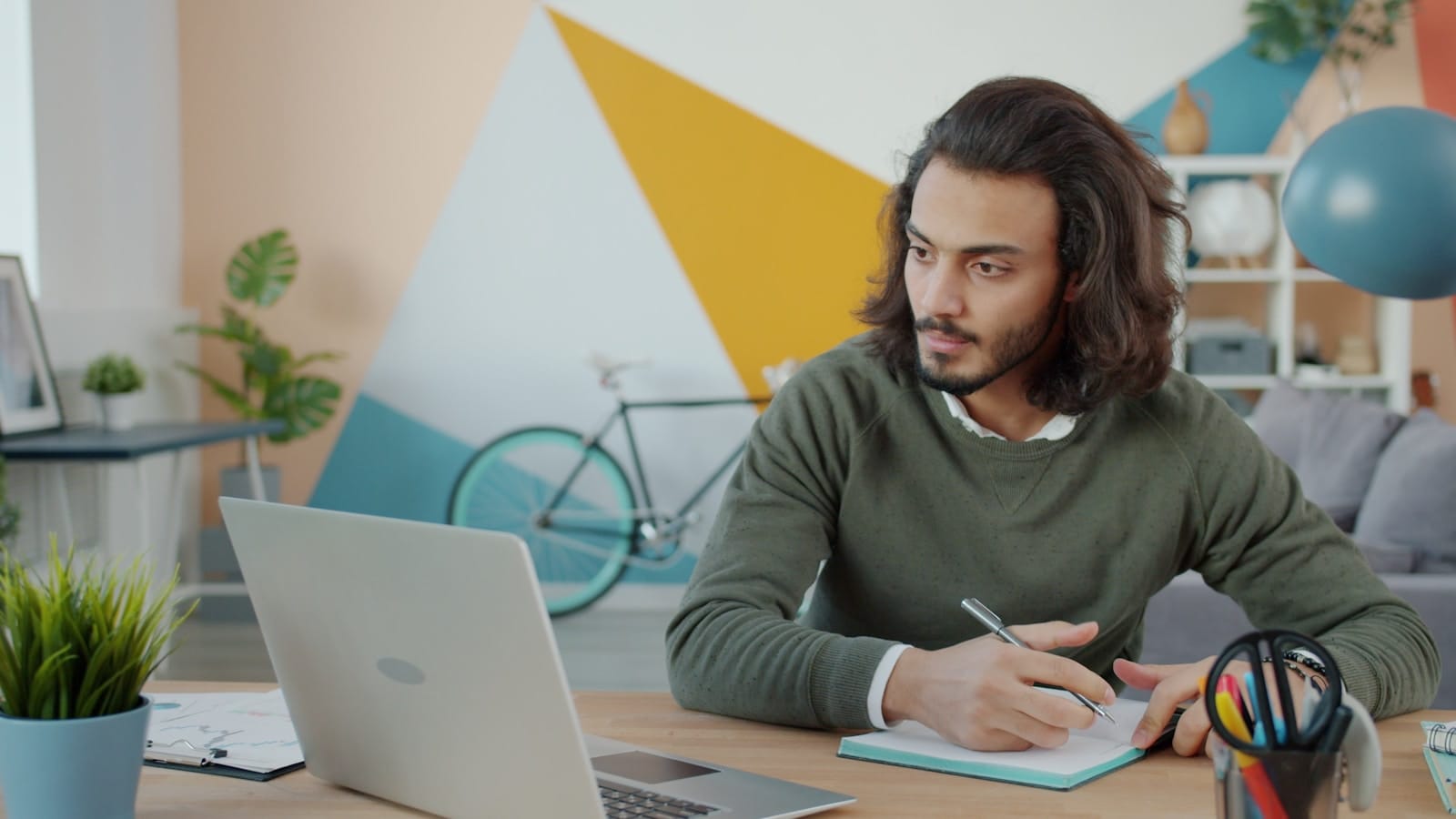 Freelancer working at a desk with laptop and notebook